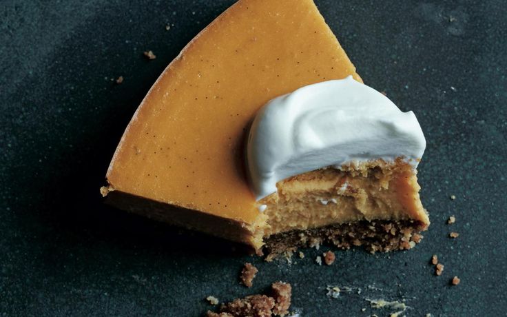 a piece of pie with icing on it sitting on top of a black surface