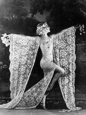 an old fashion photo of a woman with her dress draped over