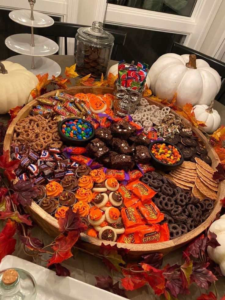 a wooden tray filled with lots of candy and candies on top of a table