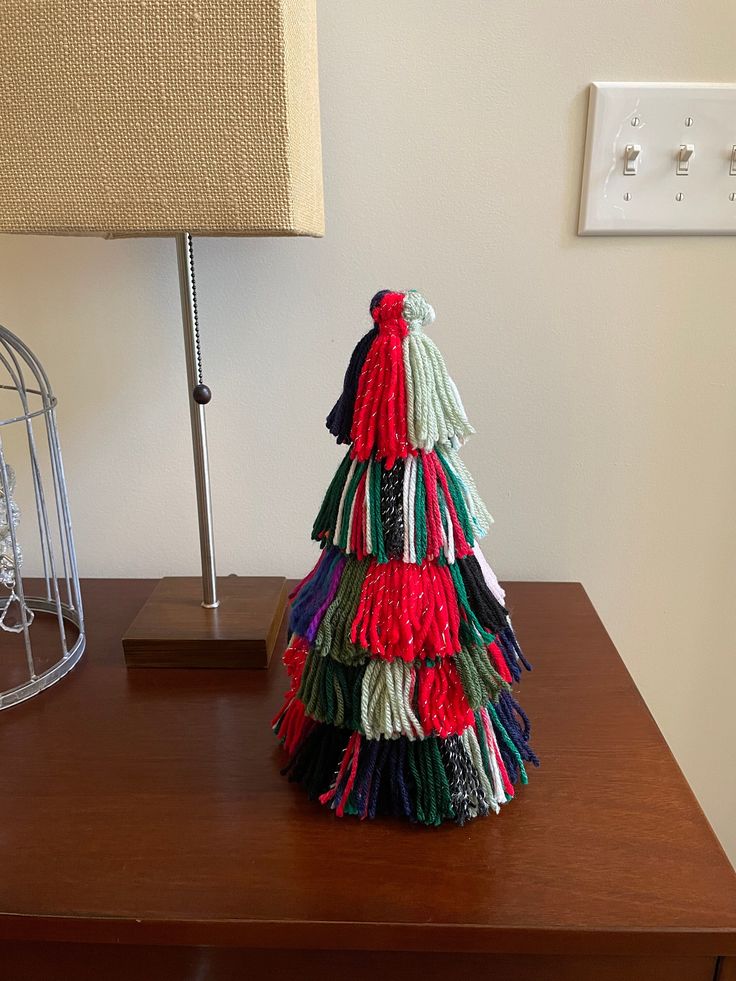 a small christmas tree sitting on top of a wooden table next to a light switch