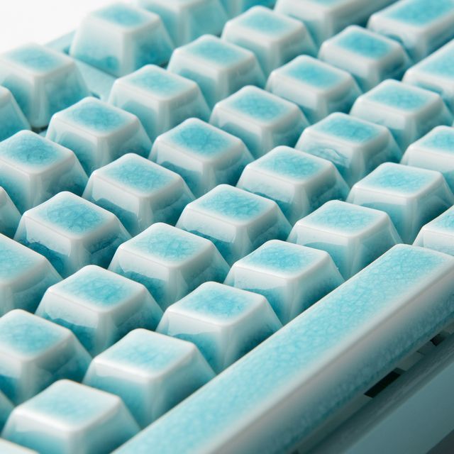 a computer keyboard with blue and white keys sitting on it's side, close up