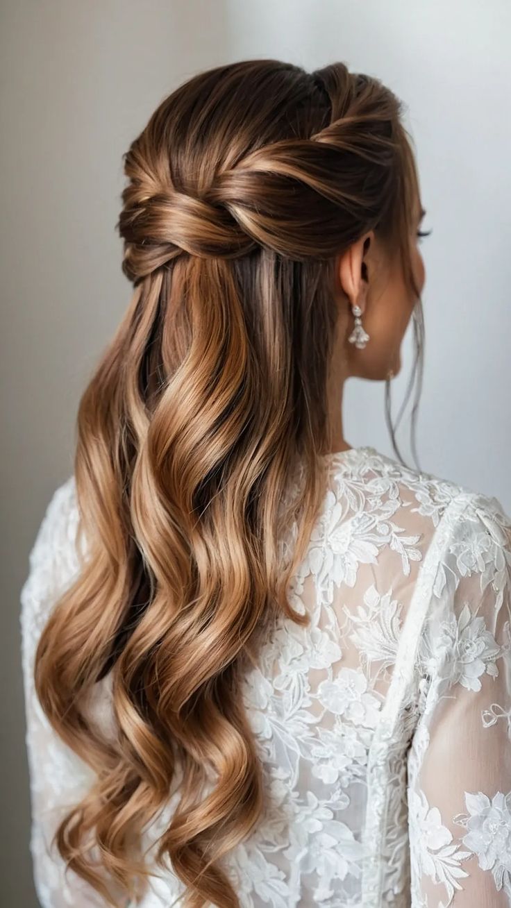 a woman with long, wavy hair wearing a half updo and an intricate braid