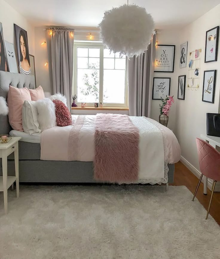 a bedroom decorated in pink and grey with pictures on the wall above the bed, along with a white rug