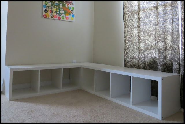 an empty room with white shelves and curtains