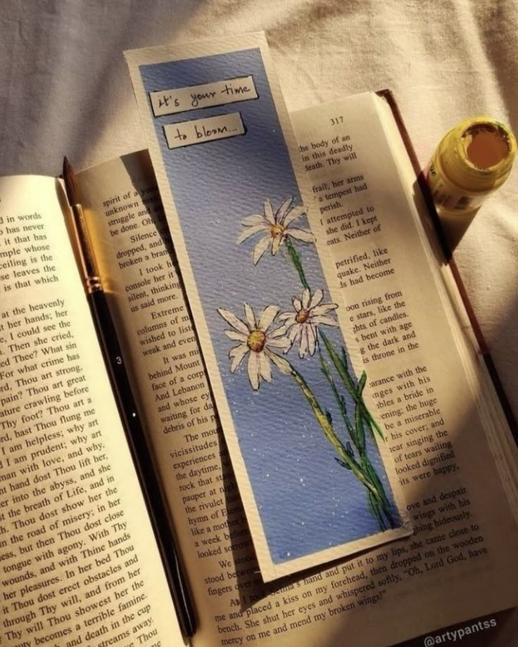 an open book with some flowers on it