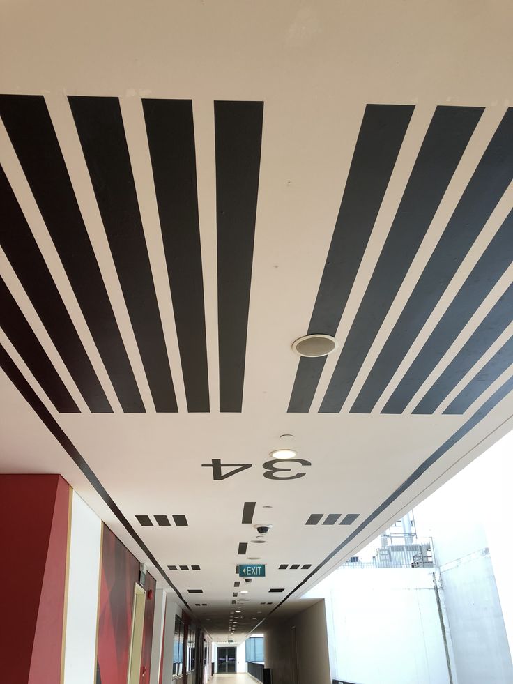 an empty hallway with black and white lines painted on the ceiling