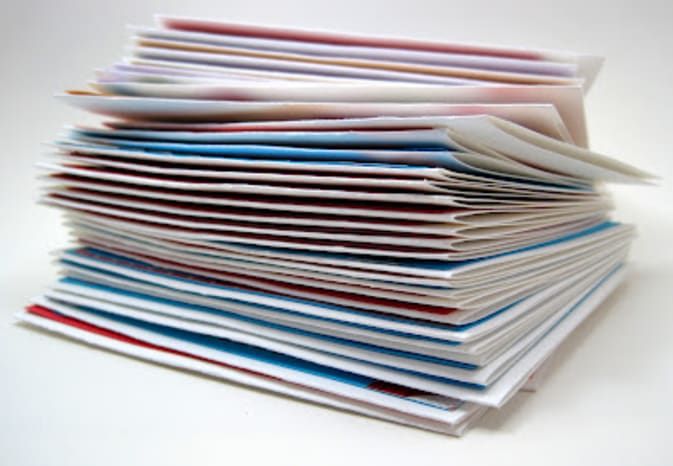 a stack of folded papers sitting on top of a white table next to each other