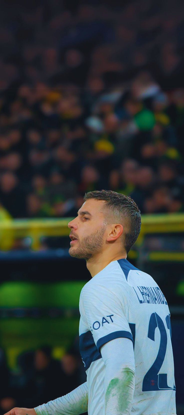 a man standing in front of a crowd with his head turned to the side and looking up