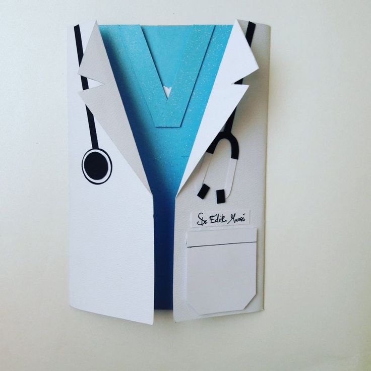 an origami doctor's coat and stethoscope hanging on the wall