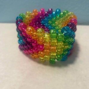 a multicolored beaded bracelet on a white surface