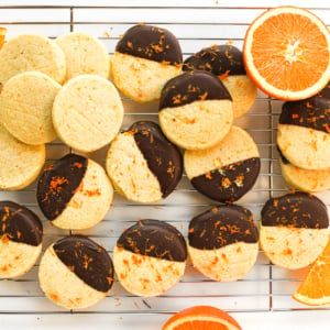 an assortment of cookies and oranges on a cooling rack