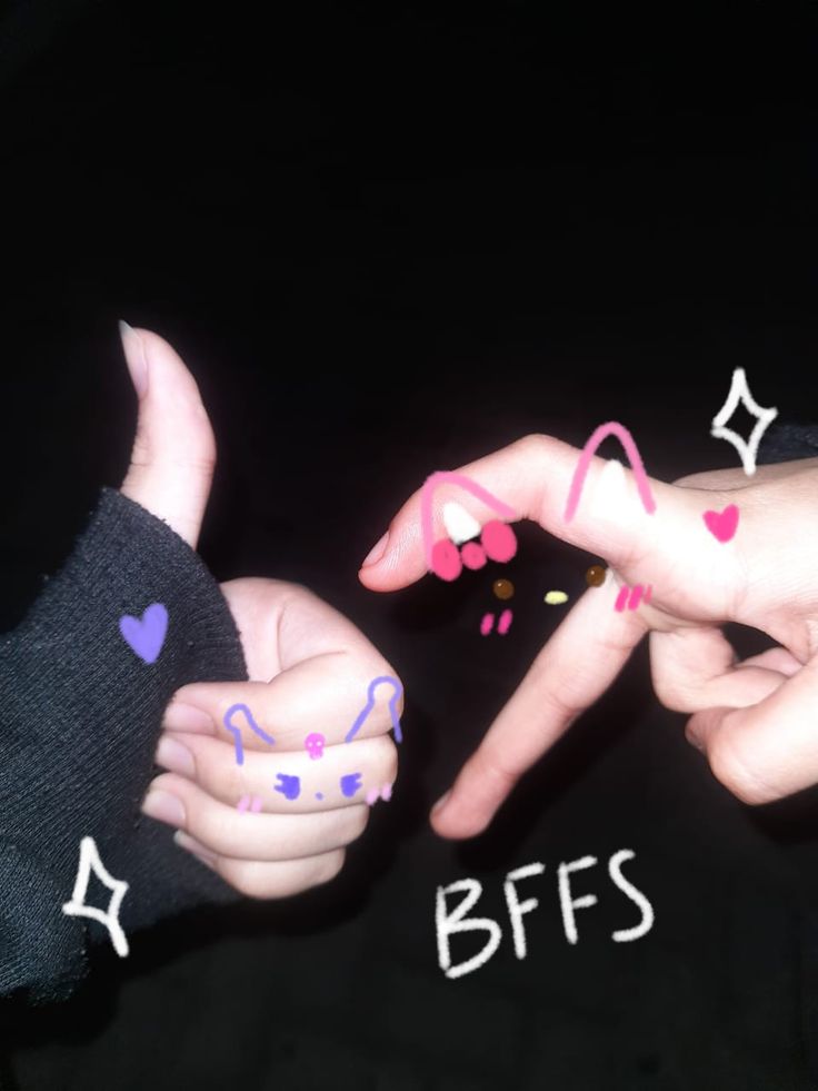 two hands with different designs on their fingers and the words bffs written in white ink