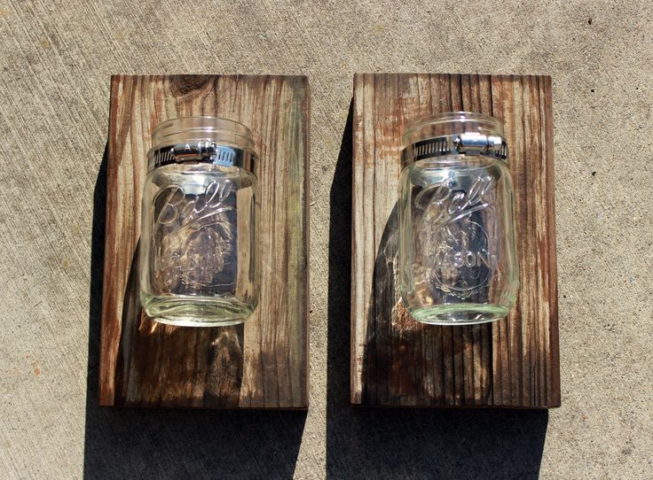 two mason jars sitting on top of wooden boards