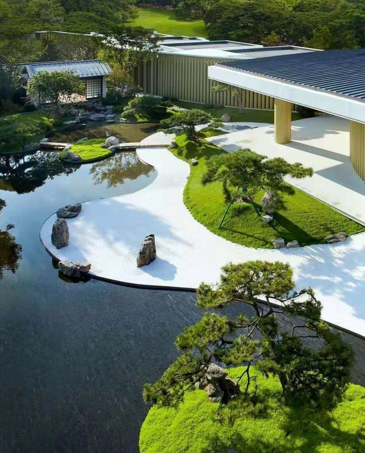 an aerial view of a building with trees and water