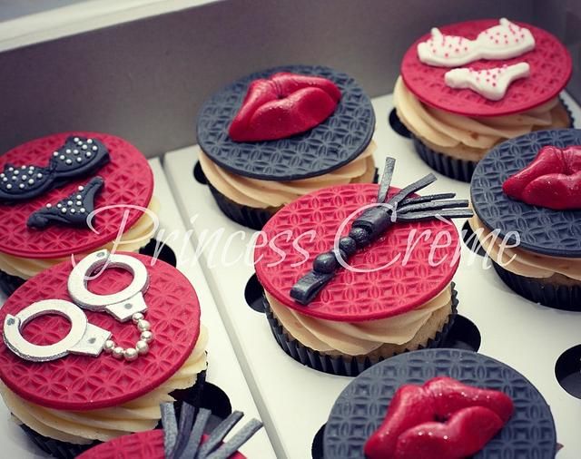 cupcakes decorated with red, black and white frosting are displayed in a box