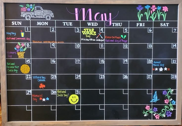 a chalkboard calendar with the month of may written on it and flowers drawn on it