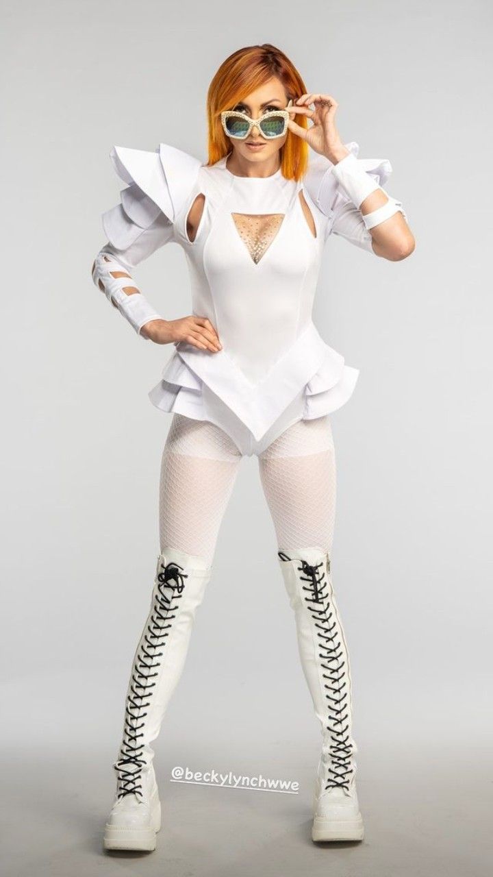 a woman in white is posing with her hands on her hips and wearing knee high boots