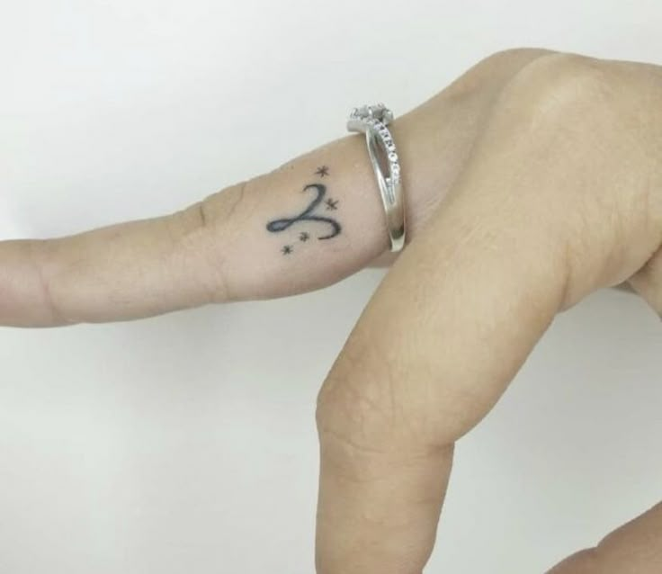 a person's hand with a small tattoo on it