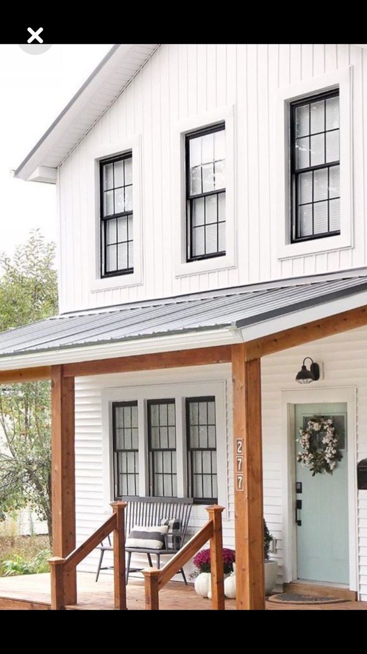 a white house with black windows and a porch