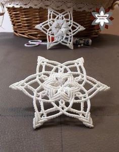 a white crochet star sitting on top of a table next to a basket