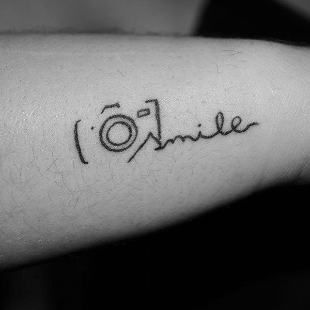 a black and white photo of a person's arm with the word smile on it