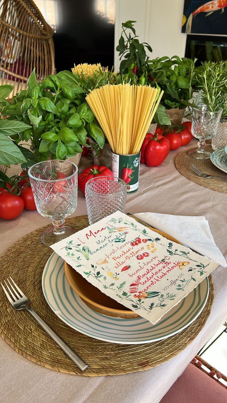 a table set with plates, napkins and vegetables on top of the place setting