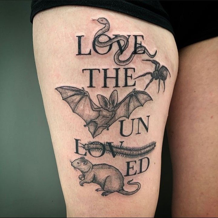 a black and white tattoo on the leg of a woman's thigh that reads, love the un - loved