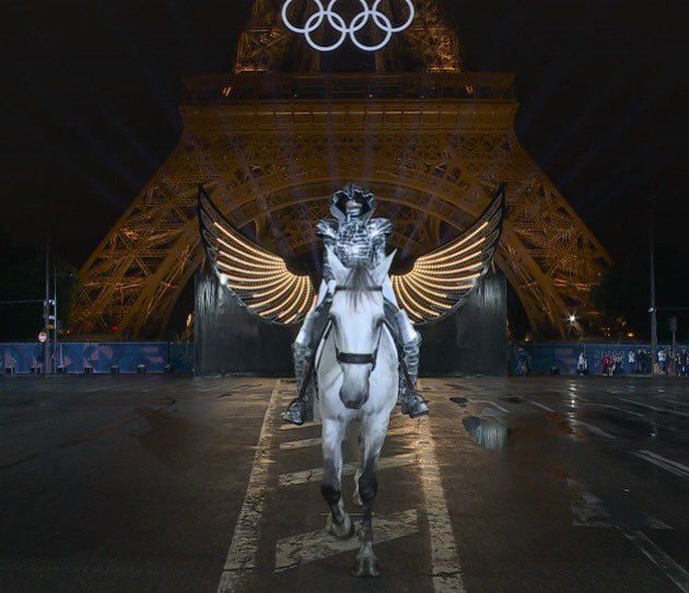 a person on a horse in front of the eiffel tower with their wings outstretched