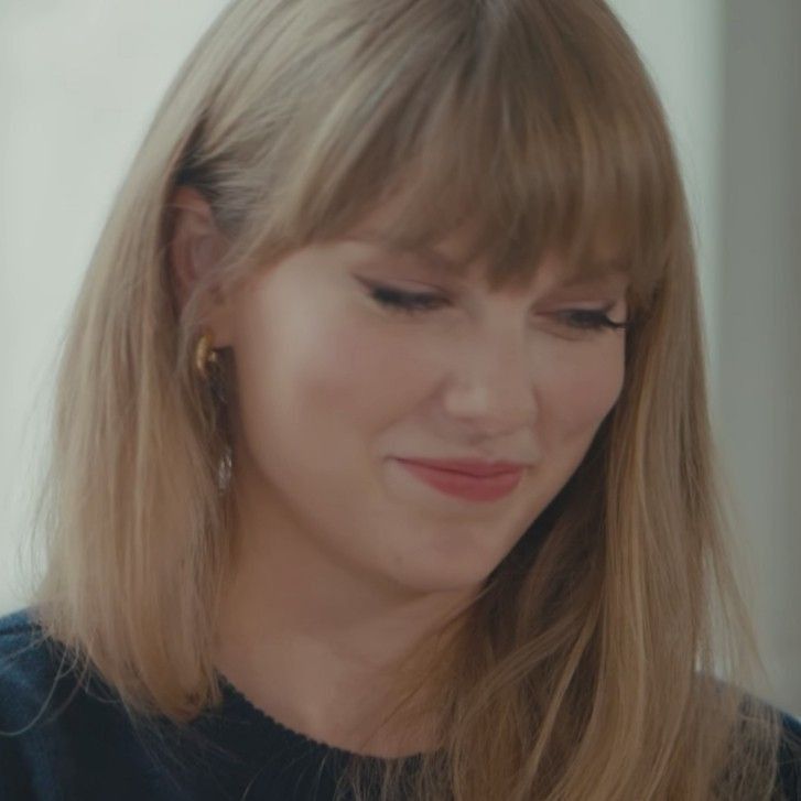 a close up of a person with long blonde hair and wearing earring's