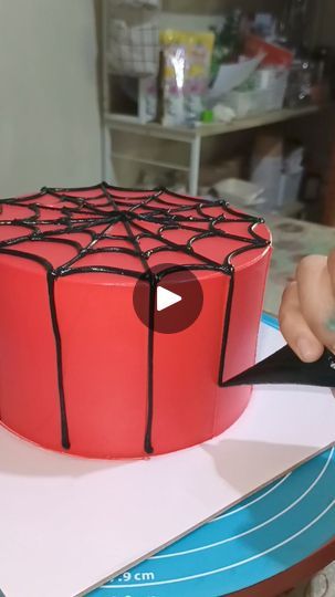 a spider web cake being cut with a pair of scissors