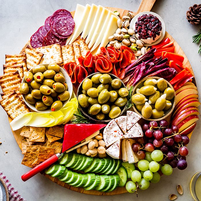 a platter filled with cheese, olives, crackers, and other foods