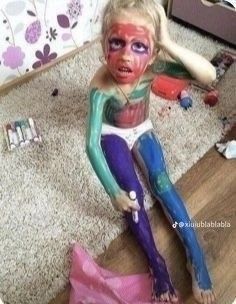 a doll is sitting on the floor with her body painted