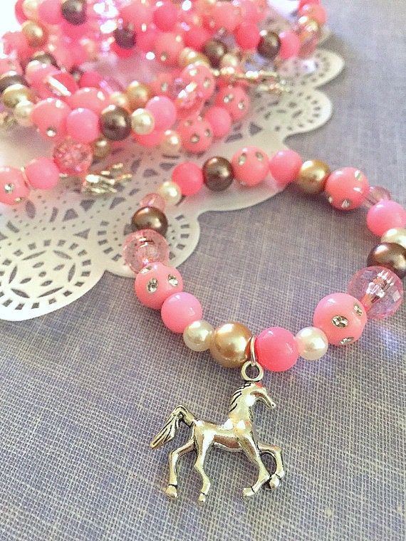 a pink and brown beaded necklace with a horse charm