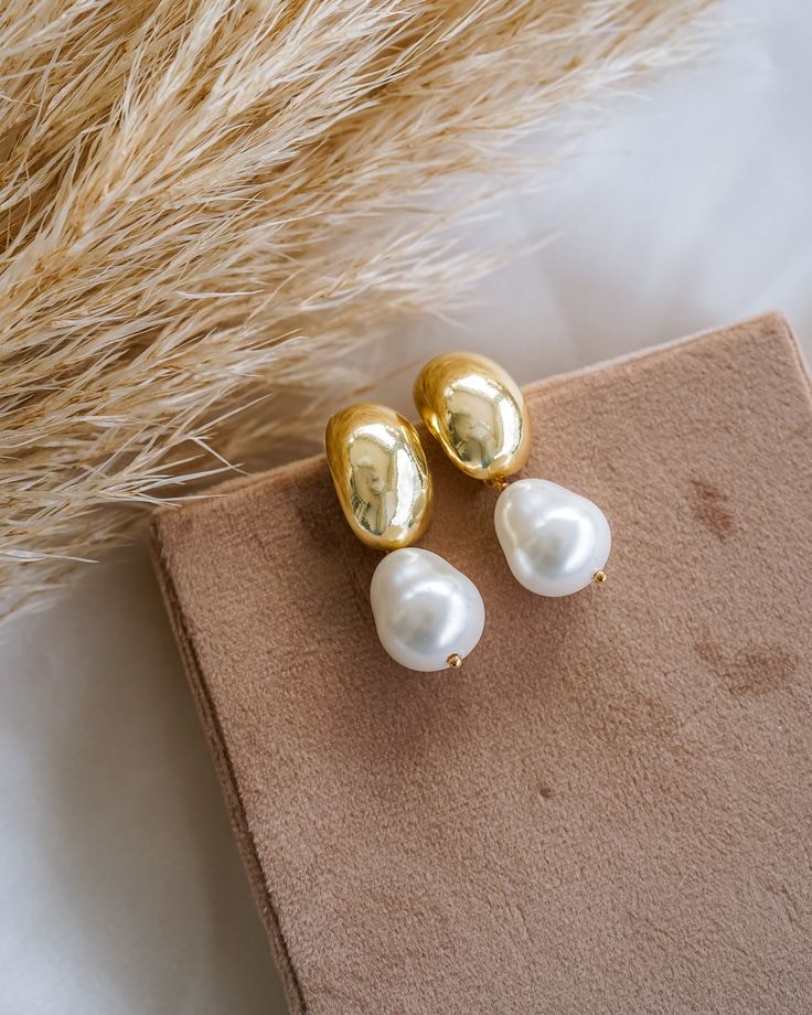 Make a timeless statement with these chic Hailey Dome Pearl Drop Earrings! Crafted in gold and featuring an elegant pearl, these earrings will be a beautiful addition to your collection. Slip them on for a sophisticated finish to any look! EARRINGS FEATURE Material: Brass, Shell Teardrop Pearls Finish: 14K Gold Filled Size: 17.9mm x 11.8mm x 18.9mm, Pearl Size 10mm x 12mm Lead & Nickel-Free Wedding Day Pearl Earrings, Wedding Earrings Bride, Business Vision, Wedding Hoop, Statement Earrings Wedding, Dainty Engagement, Brass Shell, Pearl Drop Earrings Gold, Bridal Jewels