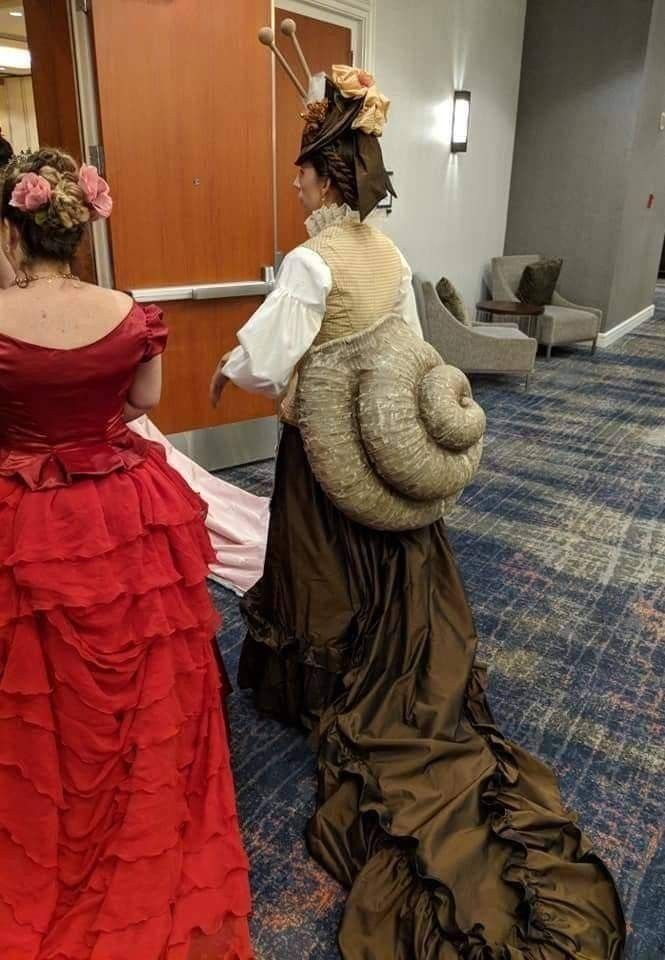 two women dressed in period costumes are sitting on the floor and one is holding an elephant