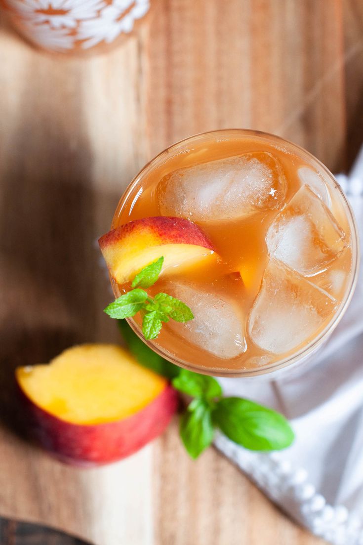 peach tea cocktail with ice and mint garnish