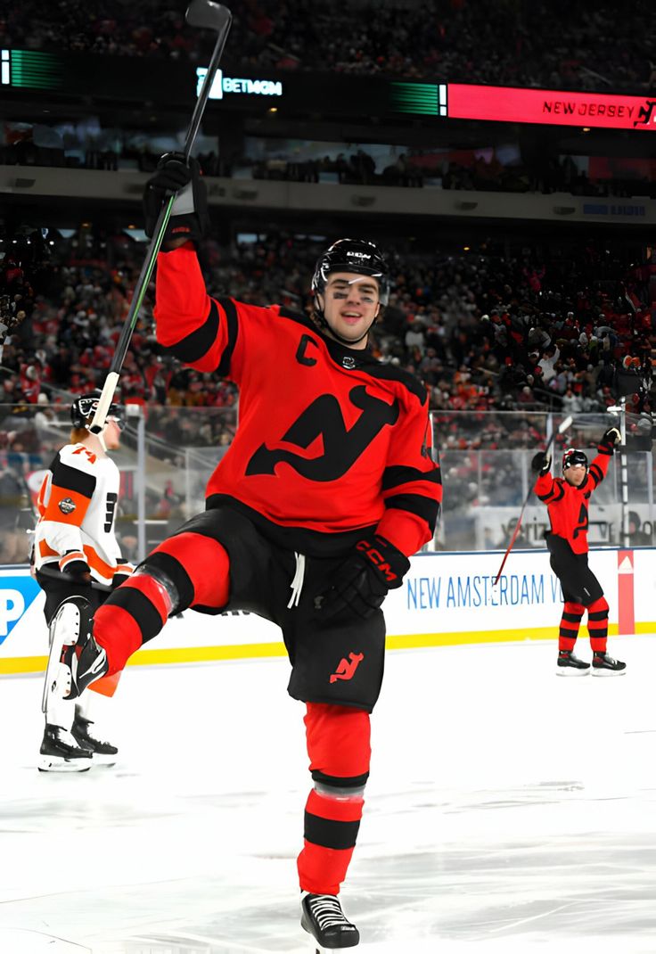 a hockey player is holding his stick in the air