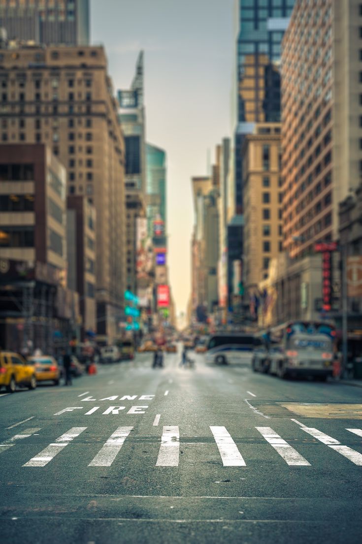 an empty city street with tall buildings and cars