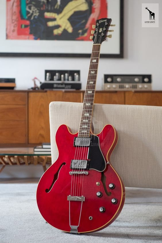 a red guitar sitting on top of a couch