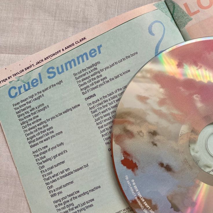 a cd sitting on top of a table next to a pink and white book cover