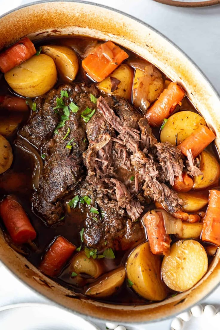 a pot full of beef stew with carrots and potatoes