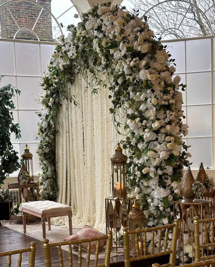 a wedding ceremony setup with white flowers and greenery