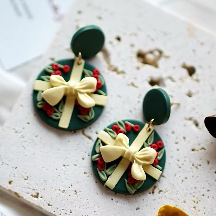 two earrings with bows on them sitting on a table next to some other items that are laying around