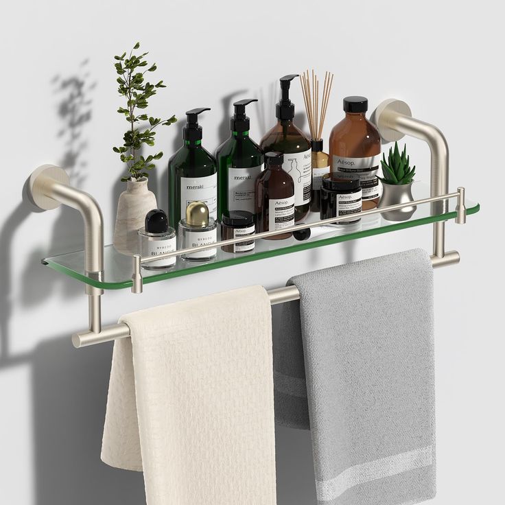 a bathroom shelf with soap, lotion and hand towels hanging on it's side