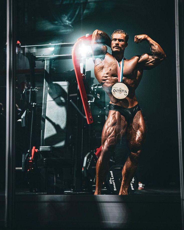 a bodybuilde posing for a photo in front of a mirror with his muscles ripped