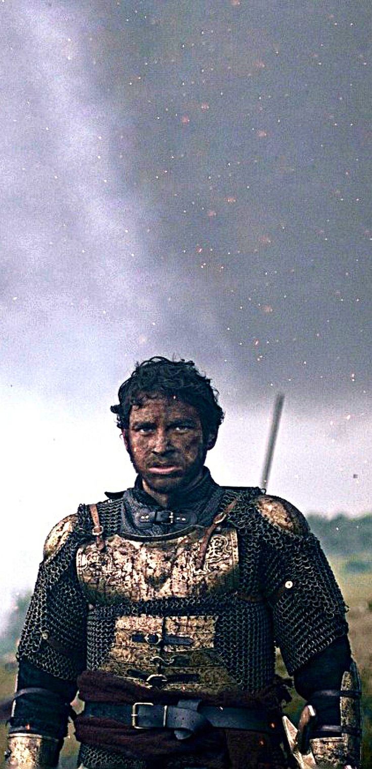 a man dressed in armor standing on a field