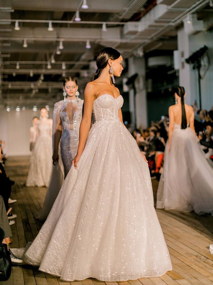 a model walks down the runway in a wedding dress