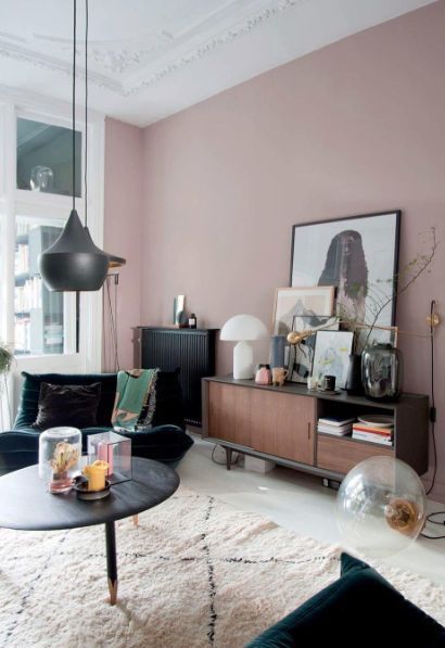 a living room with pink walls and furniture