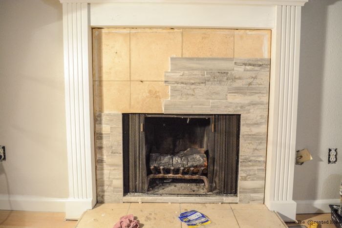 a living room with a fire place in the middle and some tools on the floor