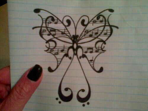 a hand holding up a piece of paper with music notes on it and a butterfly drawn in the middle